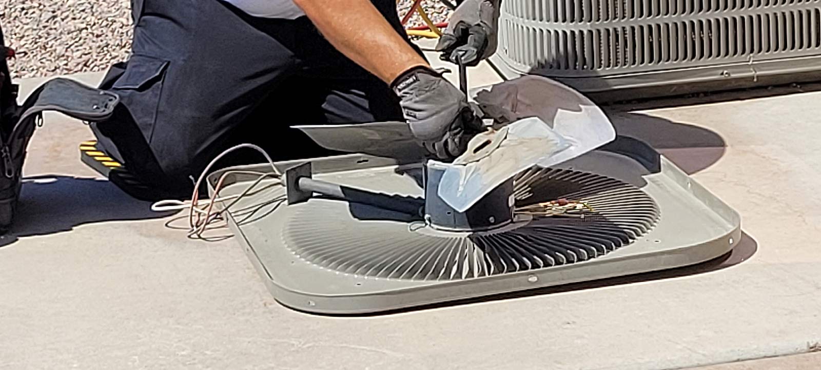 HVAC tech repairing AC fan